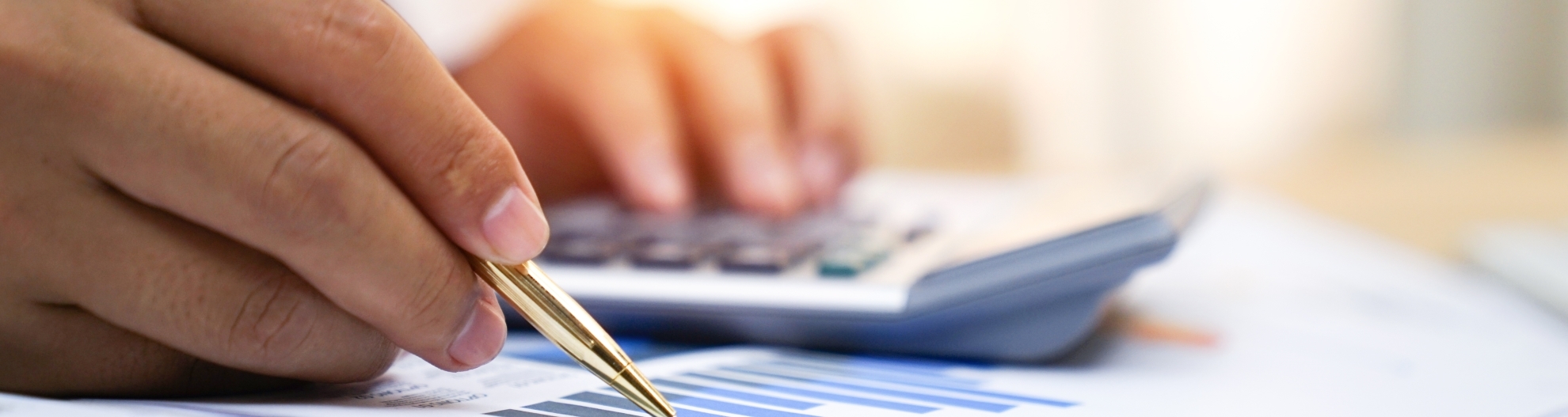 Close Up image of hands writing and using calculator